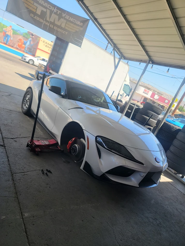 White Toyota Supra A90 up on a jack for a wheel swap